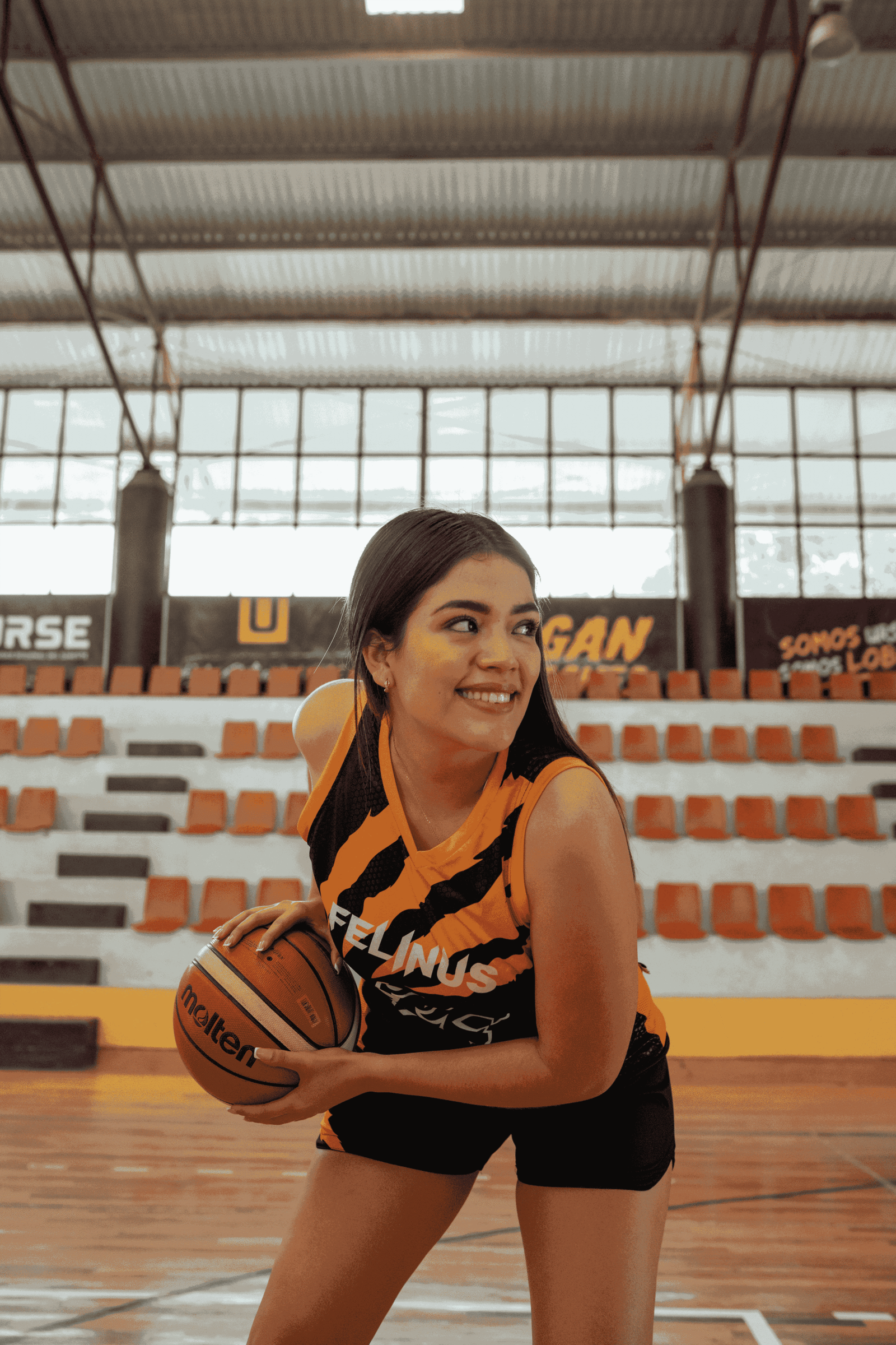 Chica con uniforme de Felinus posando a la cámara con un balón en sus manos