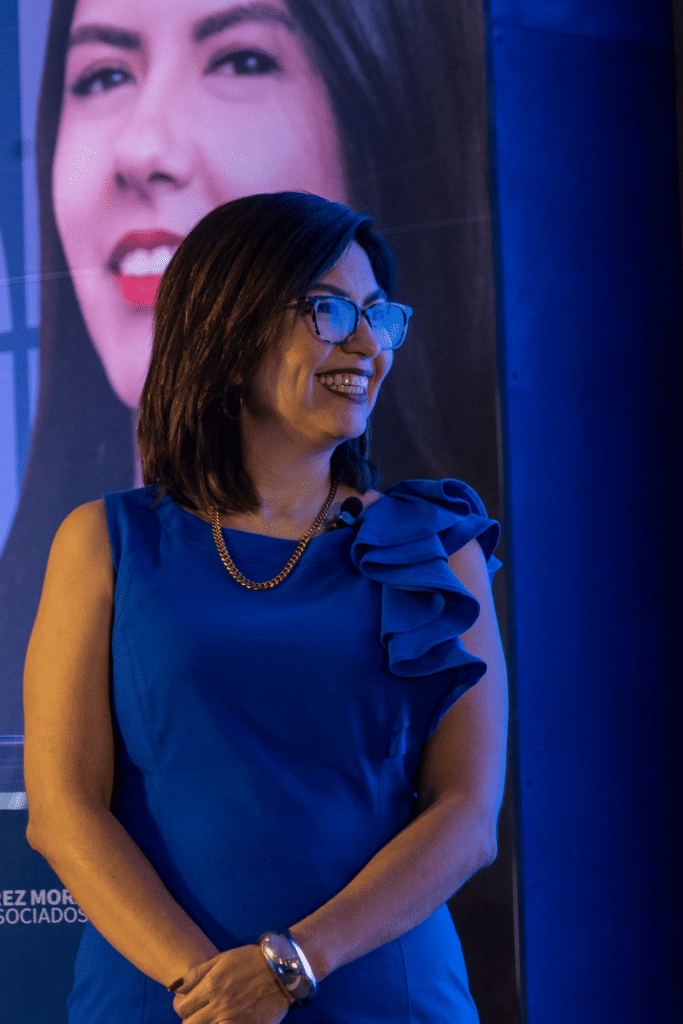 Mujer hablando en conferencia de Pérez y Mora sonriendo