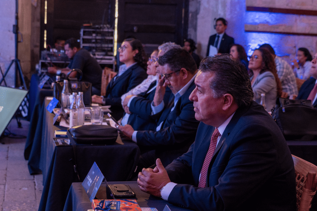 3 hombres prestando atención a conferencia de Pérez y Mora