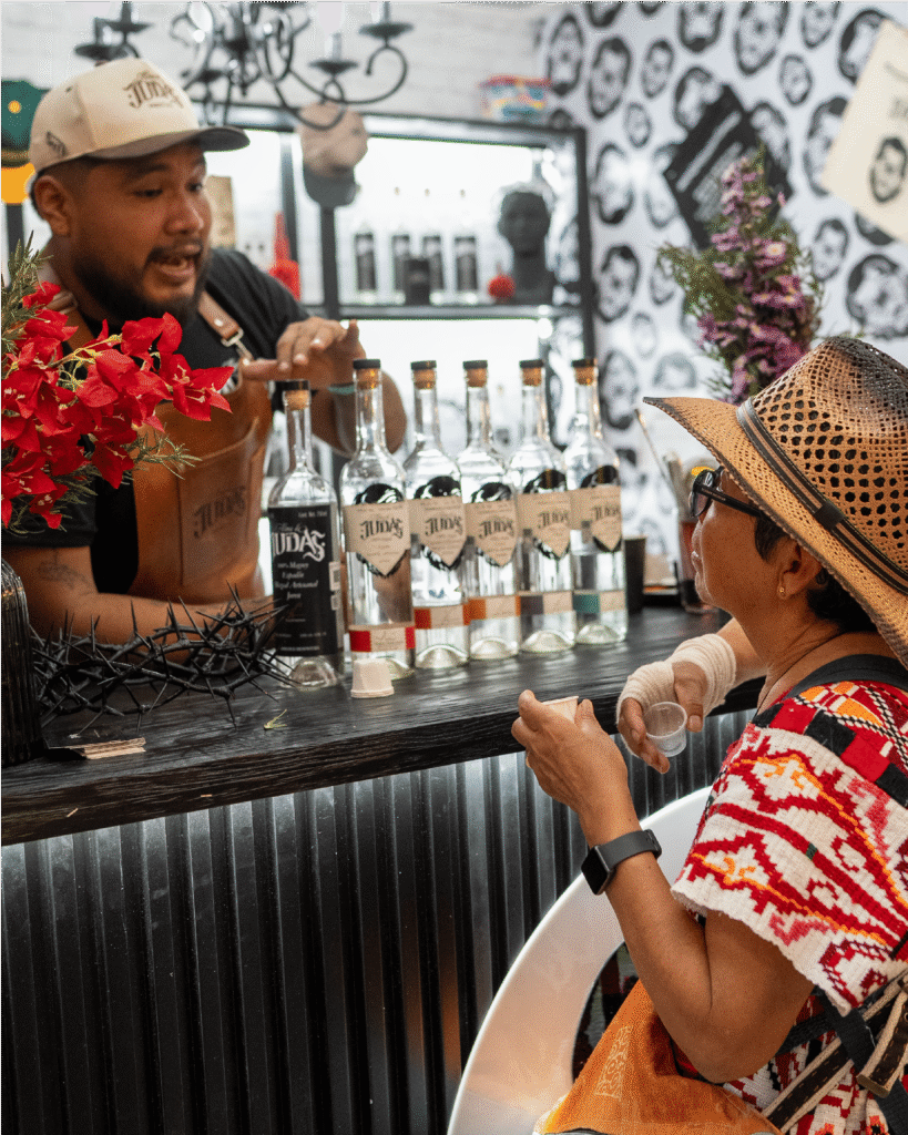 Barman y señora hablando sobre el mezcal de Alma de Judas