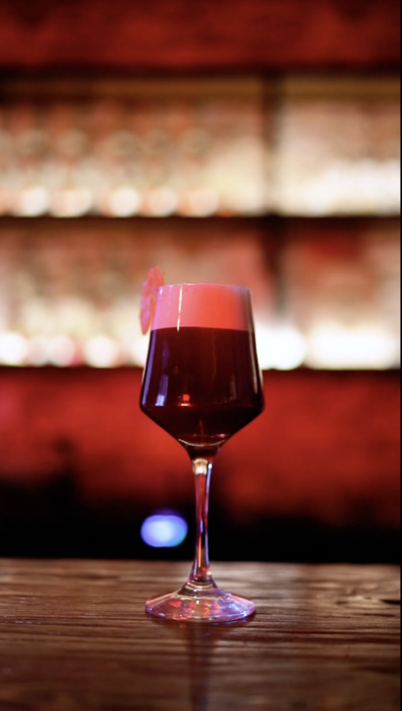 Cóctel de frutos rojos siendo preparado en un fondo elegante de un bar de Alma de Judas